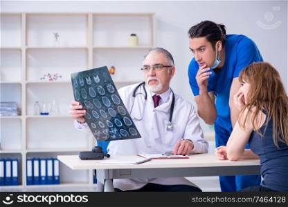 The two doctors examining young woman . Two doctors examining young woman 