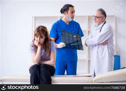 The two doctors examining young woman . Two doctors examining young woman