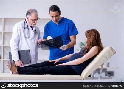 The two doctors examining young woman . Two doctors examining young woman