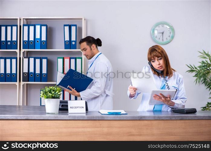 The two doctors working at the reception in the hospital. Two doctors working at the reception in the hospital