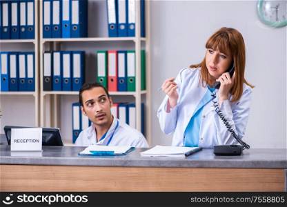 The two doctors working at the reception in the hospital. Two doctors working at the reception in the hospital