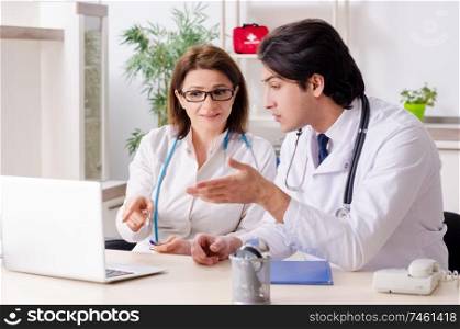 The two doctors working in the clinic . Two doctors working in the clinic 