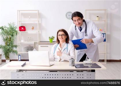 The two doctors working in the clinic . Two doctors working in the clinic