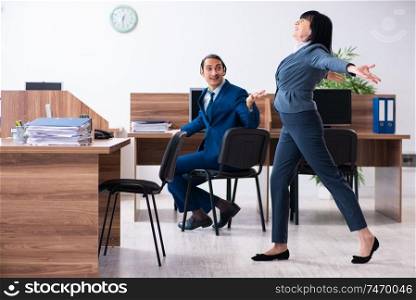 The two employees doing sport exercises in the office . Two employees doing sport exercises in the office 