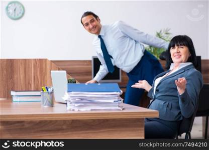 The two employees doing sport exercises in the office. Two employees doing sport exercises in the office