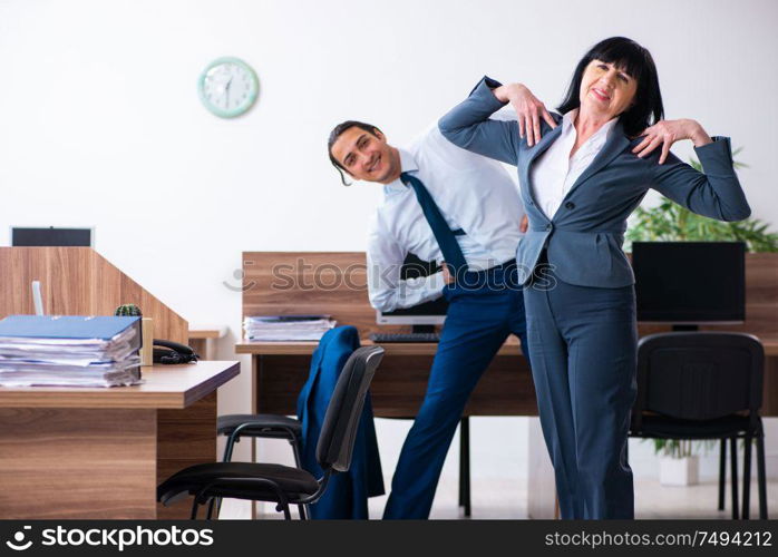 The two employees doing sport exercises in the office. Two employees doing sport exercises in the office