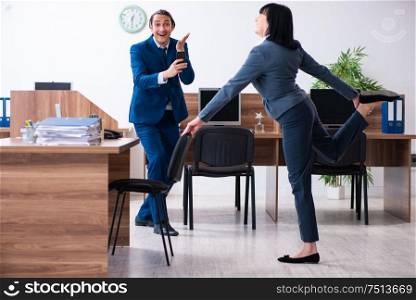 The two employees doing sport exercises in the office. Two employees doing sport exercises in the office