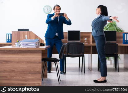 The two employees doing sport exercises in the office. Two employees doing sport exercises in the office