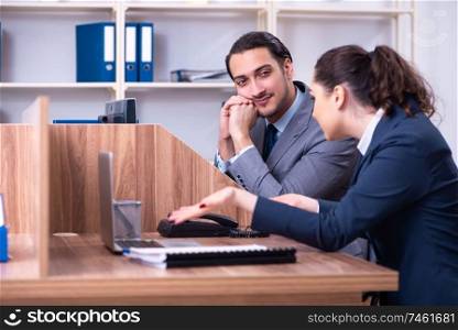 The two employees working in the office . Two employees working in the office 