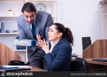 The two employees working in the office . Two employees working in the office