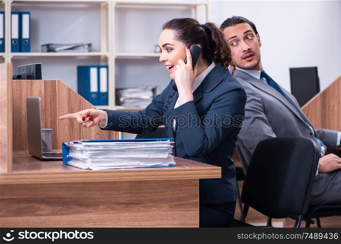 The two employees working in the office . Two employees working in the office