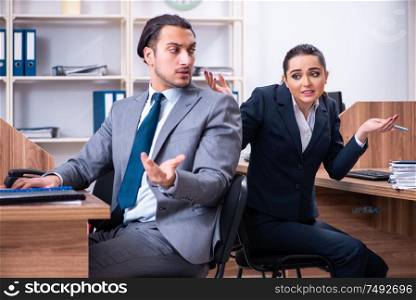 The two employees working in the office. Two employees working in the office