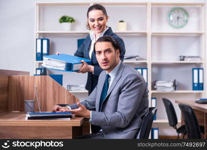 The two employees working in the office. Two employees working in the office