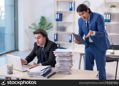 The two male colleagues unhappy with excessive work. Two male colleagues unhappy with excessive work