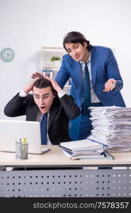 The two male colleagues unhappy with excessive work. Two male colleagues unhappy with excessive work