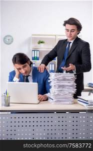 The two male colleagues unhappy with excessive work. Two male colleagues unhappy with excessive work