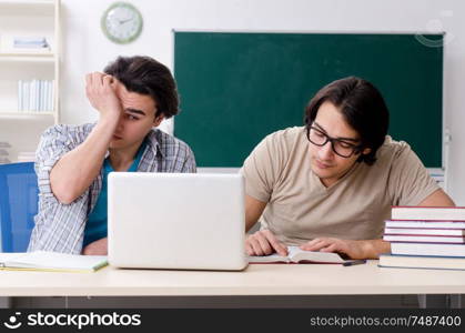 The two male students in the classroom . Two male students in the classroom