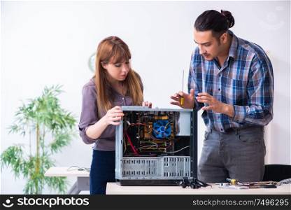 The two repairmen repairing desktop computer. Two repairmen repairing desktop computer