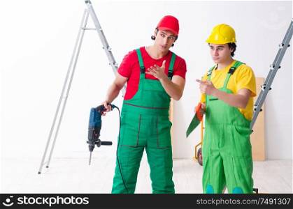 The two workers contractors working indoors. Two workers contractors working indoors