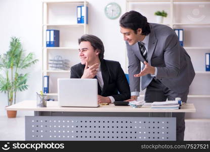 The two young employees working in the office. Two young employees working in the office