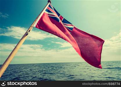 The uk red ensign the british maritime flag flown from yacht sail boat, blue sky and baltic sea. Summer and travel voyage. uk red ensign the british maritime flag flown from yacht