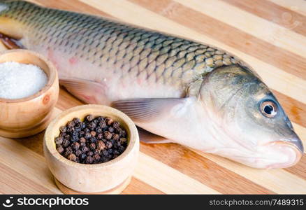 The uncooked fish on cutting board in meal preparation concept. Uncooked fish on cutting board in meal preparation concept