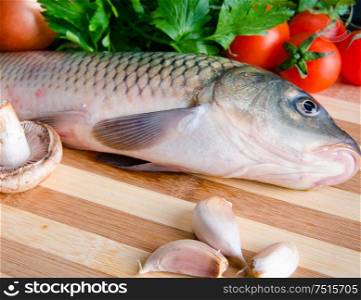 The uncooked fish on cutting board in meal preparation concept. Uncooked fish on cutting board in meal preparation concept