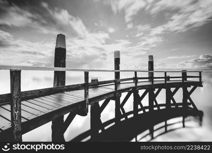 The unesco wadden sea nature aprk with its endless views and beautiful cloudy skies. Wooden mooring jetty in seaport with a view over the Dutch Wadden Sea