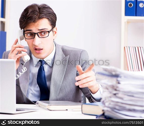 The unhappy businessman working in office. Unhappy businessman working in office