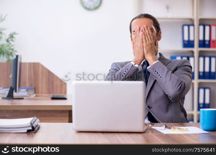 The unhappy male businessman in the office. Unhappy male businessman in the office