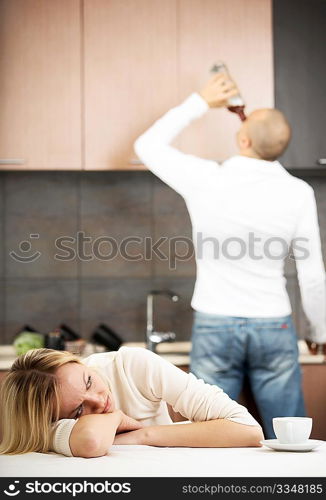 The upset wife against the drunk husband on kitchen