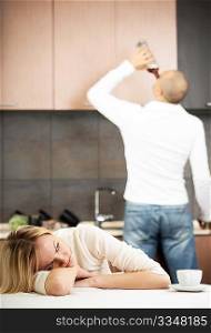 The upset wife against the drunk husband on kitchen