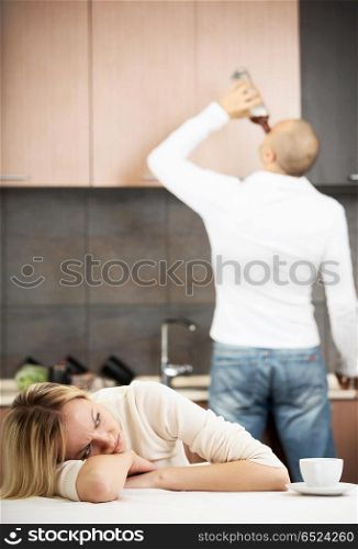 The upset wife against the drunk husband on kitchen. Household alcoholism