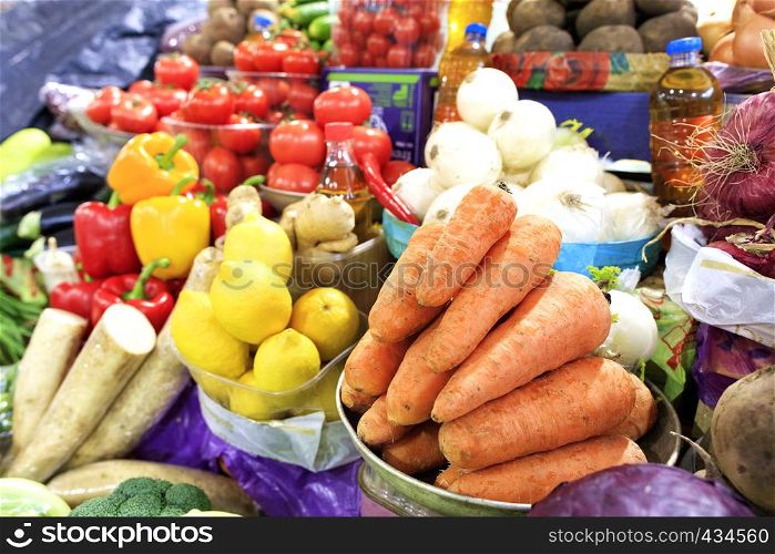 The vegetable market sells many different vegetables, such as carrots, tomatoes, onions, beets, potatoes, parsley roots, parsnips, eggplants, and lemons and sunflower oil.. Carrots, tomatoes, onions, peppers and other vegetables, root vegetables and lemons, sunflower oil are sold on the market shelves.