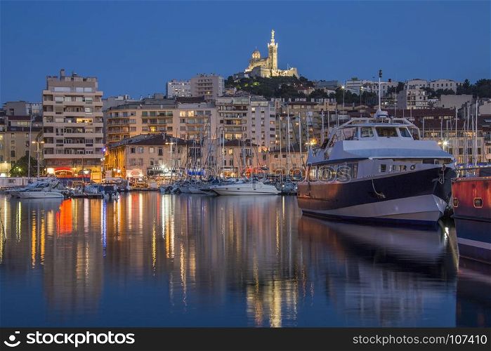 The Vieux Port area of Marseille in the Cote d'Azur region of the South of France. Looking towards the Cathedral de Notre-Dame-de-la-Garde high on a hill overlooking the city.