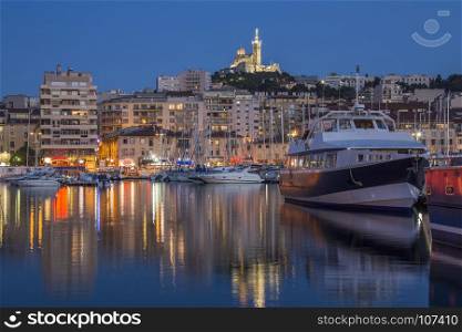The Vieux Port area of Marseille in the Cote d'Azur region of the South of France. Looking towards the Cathedral de Notre-Dame-de-la-Garde high on a hill overlooking the city.