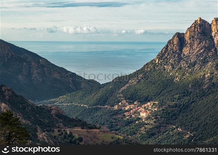 The village of Ota in Corsica with mountains and the Mediterranean sea behind