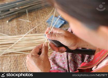 The villager took bamboo stripes to weaving basket