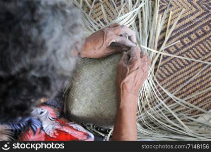 The villager took bamboo stripes to weaving basket