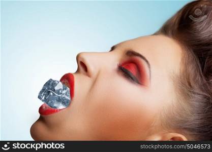 The vintage photo of a pretty girls face with a cool cube of ice in the lips.