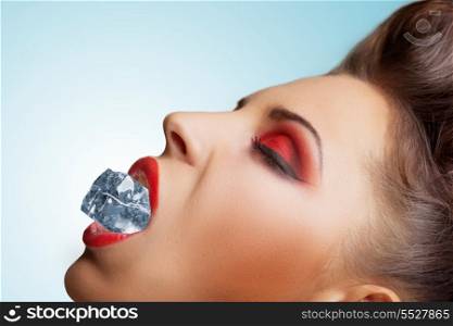 The vintage photo of a pretty girls face with a cool cube of ice in the lips.