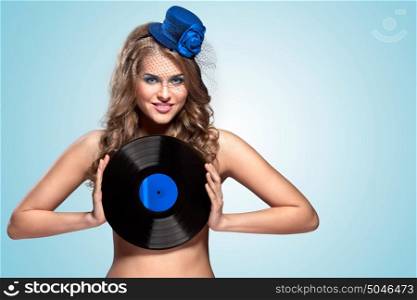 The vintage photo of girl in vintage hat holding vinyl record.