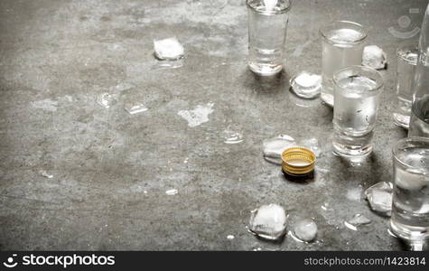 The vodka glass with ice. On the stone table.. The vodka glass with ice.