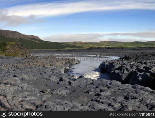 The volcanic basalt structures have given way to the eroding powers of the river, wearing out a steep canyon in the Icelandic rock formations