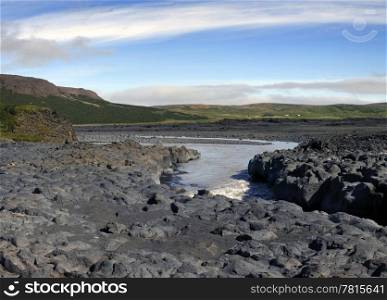 The volcanic basalt structures have given way to the eroding powers of the river, wearing out a steep canyon in the Icelandic rock formations