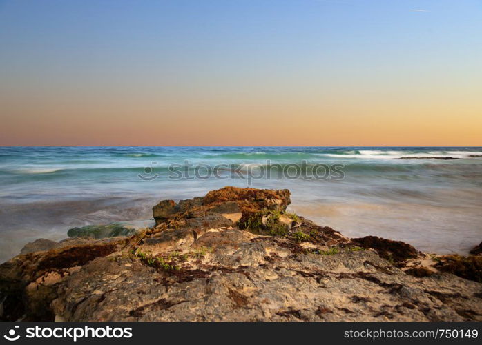 The warm light at the beach with some rocks