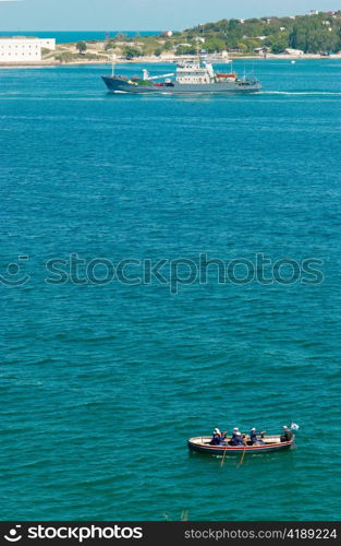 The warship and the boat with sailors.