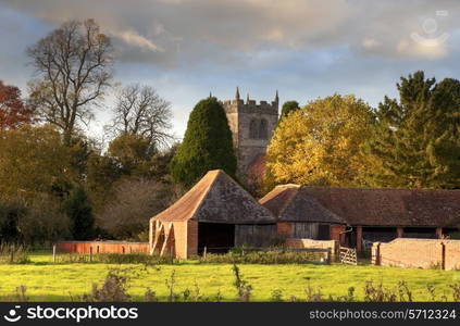 The Warwickshire village of Aston Cantlow, showing old church and barns, England.