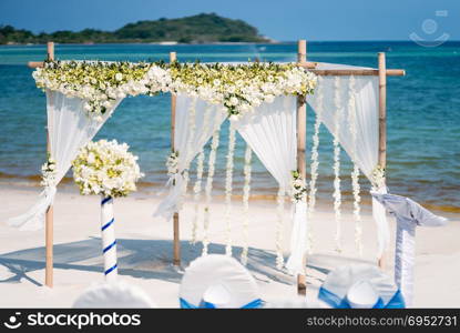 The wedding venue decoration on the beach, Arch decorated with flowers, floral, The panoramic ocean in the background. Blue and clear sky around 5pm before sunset. Koh Samui, Thailand.. Wedding Arch Decoration, Flower, Floral, Beach Wedding Venue
