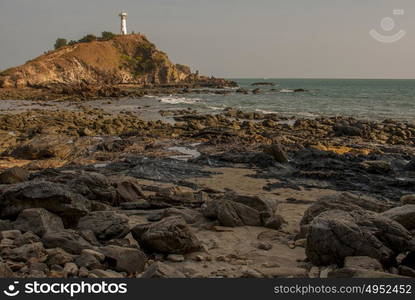 The white lighthouse is located on the seaside island.